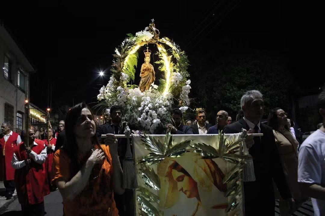 Imagem de Nossa Senhora iluminada durante a procissão noturna